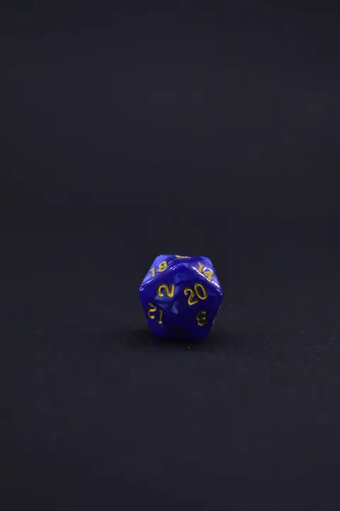 Close-up of a blue twenty-sided dice resting on a black background.